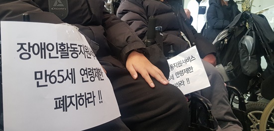 10일 기자회견에 참석한 장애인의 전동휠체어에 ‘장애인 활동지원 만 65세 연령제한 폐지하라’가 쓰인 종이가 붙어있다.ⓒ에이블뉴스 