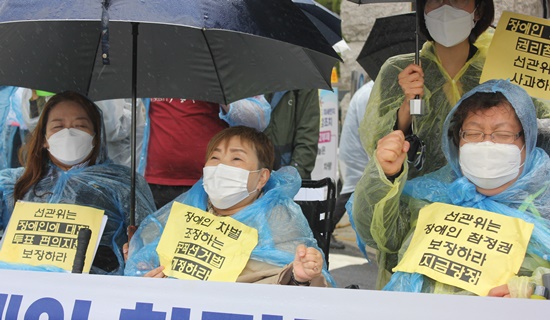 19일 비가 주룩주룩 내리는 경기도 과천에 있는 중앙선거관리위원회 앞에서 장애인차별금지추진연대 등 6개 단체로 구성된 장애인 참정권 확보를 위한 대응팀(이하 대응팀)이 “장애인 참정권을 보장하라”고 외쳤다.ⓒ에이블뉴스 