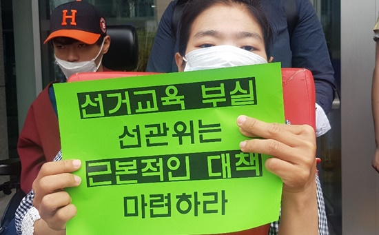 ‘선거교육 부실 선관위는 근본적인 대책 마련하라!’ 종이를 든 중증장애인 활동가.ⓒ에이블뉴스