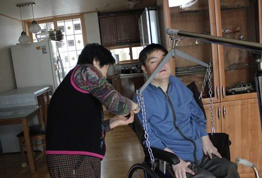 노모의 도움을 받고 있는 척수장애인 모습(기사 내용과 무관).ⓒ에이블뉴스DB