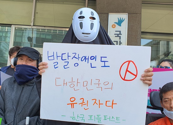 가오나시 가면을 쓴 채 ‘발달장애인도 대한민국 유권자다’ 피켓을 들고 있는 활동가.ⓒ장애인차별금지추진연대