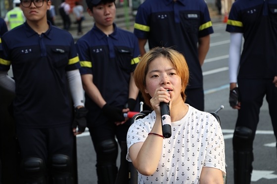 1일 사회보장위원회 앞에서 열린 전국장애인차별철폐연대 '장애등급제 진짜 폐지 예산 쟁취' 집중집회 도로 행진 중 문애린 서울장애인차별철폐연대 상임대표가 발언하고 있다. ⓒ에이블뉴스