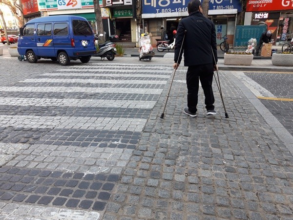 서면 사고석 도로 위로 걸어가는 지체장애인. ⓒ이복남